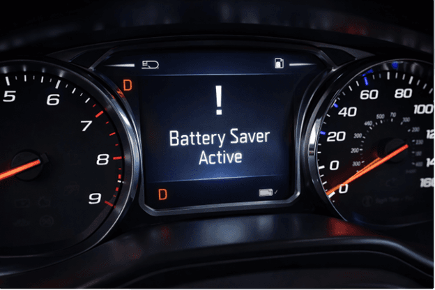 Car dashboard showing battery saver active warning message on digital instrument cluster