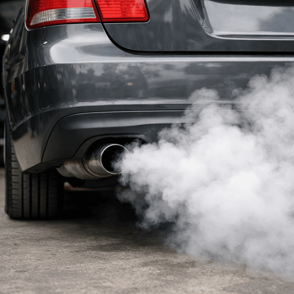 white smoke from exhaust coming from a car tailpipe